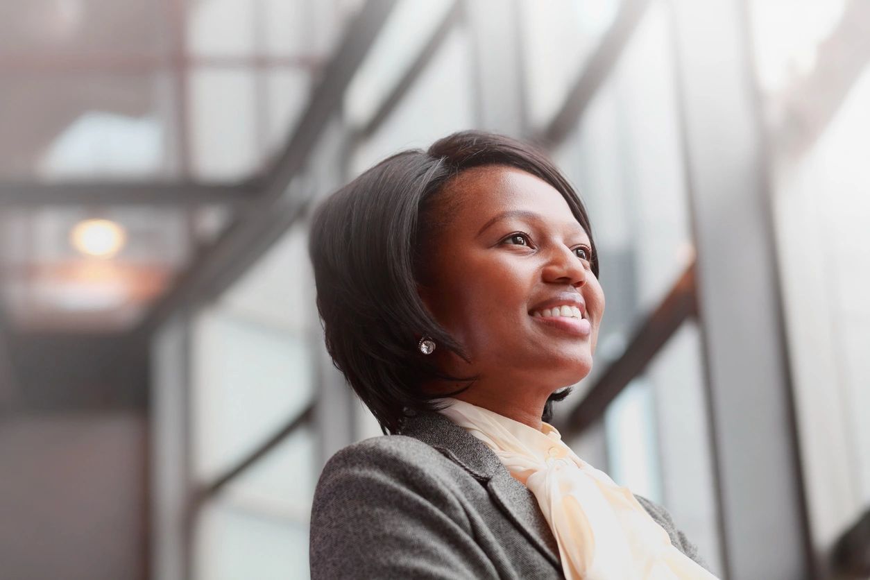 A woman in a suit and tie smiling.